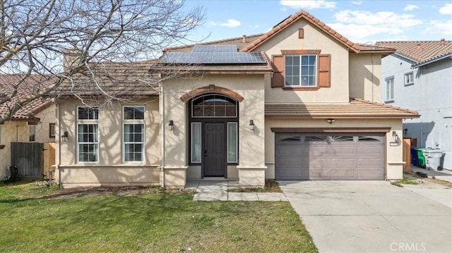 mediterranean / spanish home with stucco siding, a tiled roof, an attached garage, and solar panels