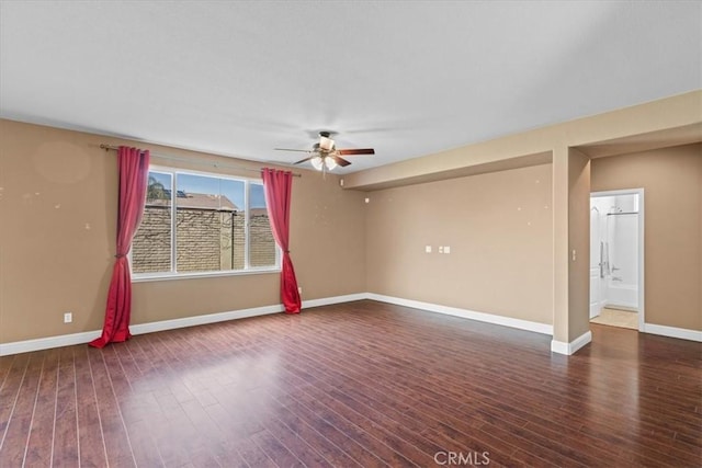 empty room featuring a ceiling fan, wood finished floors, and baseboards