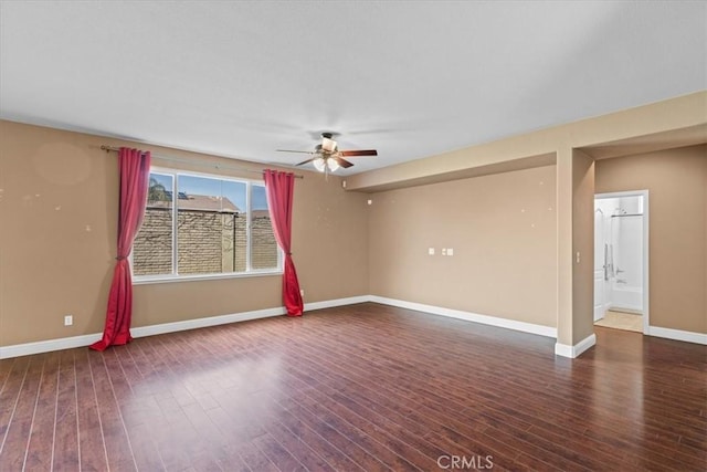 spare room with baseboards, wood finished floors, and a ceiling fan