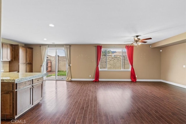 interior space with ceiling fan, baseboards, open floor plan, recessed lighting, and dark wood-style flooring