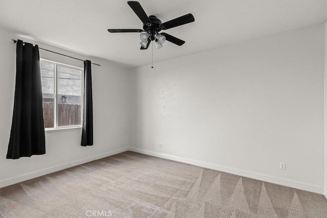empty room featuring ceiling fan, baseboards, and carpet
