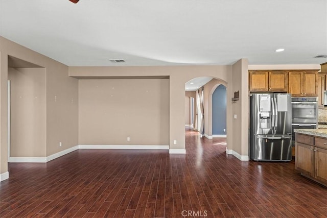 kitchen with dark wood finished floors, brown cabinets, visible vents, and stainless steel appliances