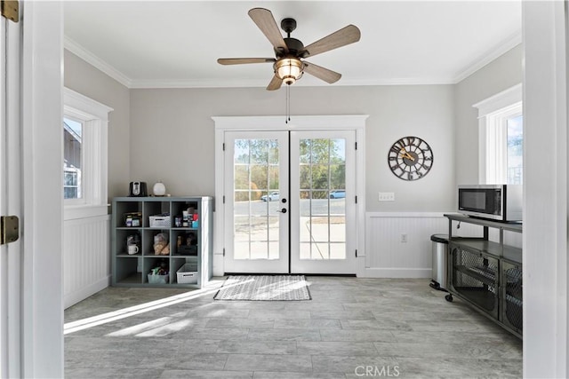 entryway with wainscoting, a healthy amount of sunlight, french doors, and crown molding