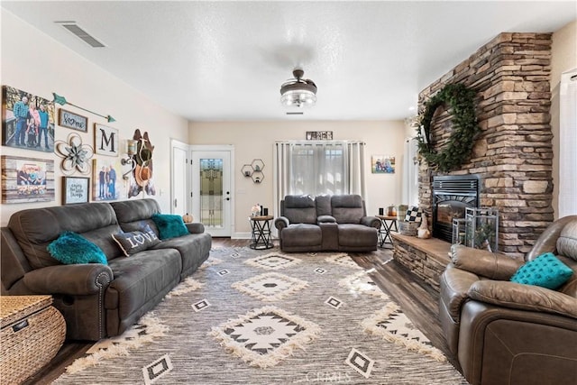 living area featuring wood finished floors, visible vents, and baseboards