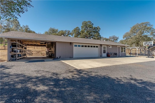 view of front of property featuring a garage, an outbuilding, and fence