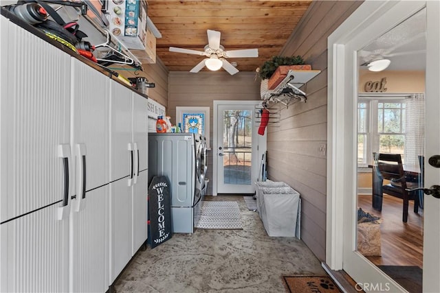 laundry area featuring washing machine and dryer, wooden walls, wooden ceiling, ceiling fan, and laundry area