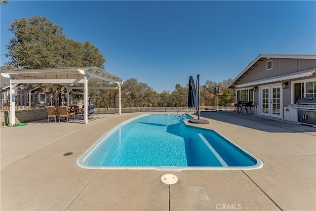 view of pool featuring a patio area, french doors, a fenced in pool, and a fenced backyard