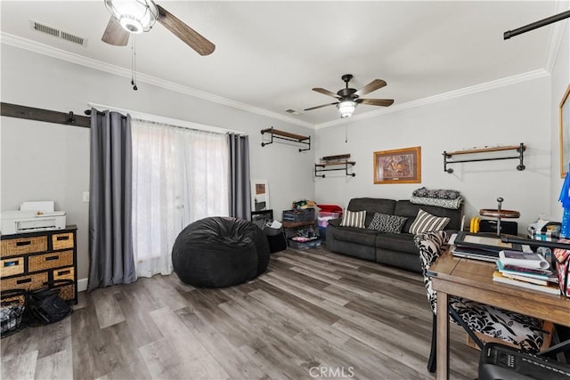 living area with visible vents, wood finished floors, and ornamental molding