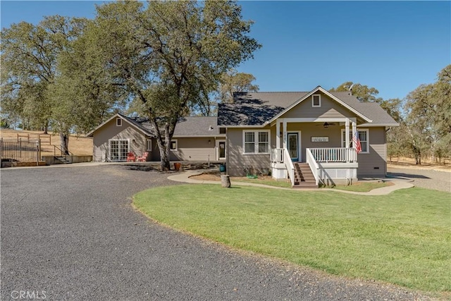 view of front of property with covered porch, fence, a front yard, and ceiling fan