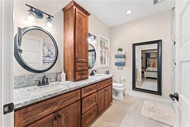 full bath with a sink, toilet, ensuite bath, and double vanity