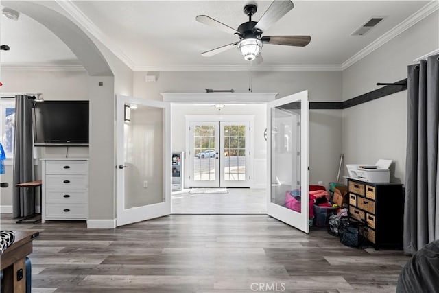 interior space with wood finished floors, french doors, visible vents, and arched walkways