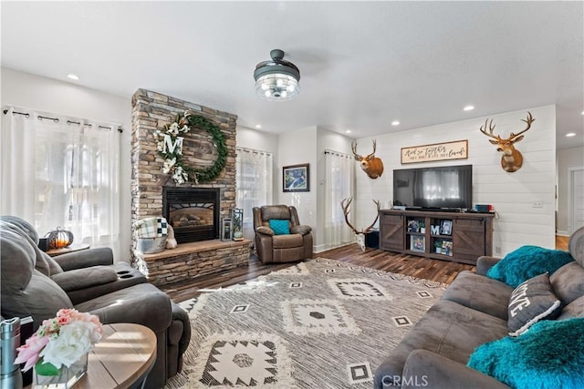 living room with recessed lighting, a fireplace, and wood finished floors