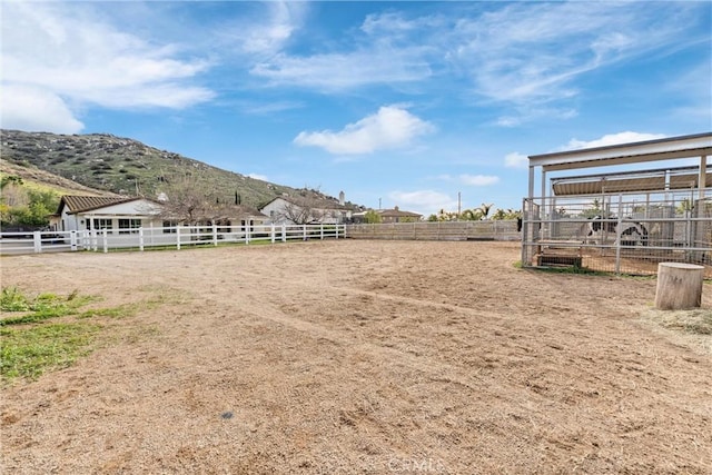 view of yard with an enclosed area, fence, and a mountain view