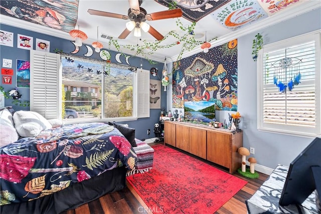 bedroom with visible vents, wood finished floors, baseboards, and ornamental molding