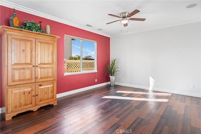 spare room with ceiling fan, wood finished floors, baseboards, and ornamental molding