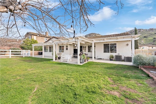 rear view of house with a patio, fence, a yard, a pergola, and stucco siding