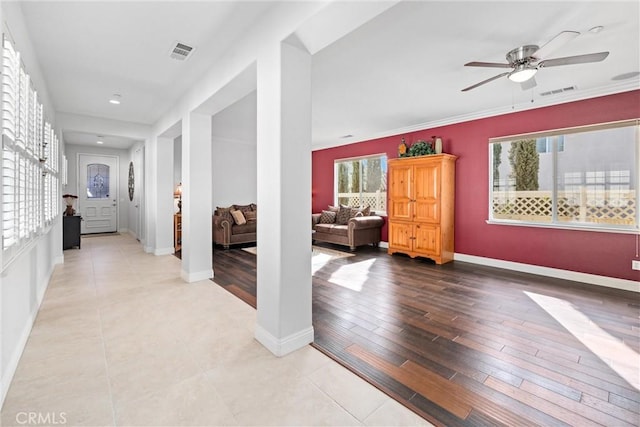 hallway featuring light wood-style flooring, baseboards, and visible vents