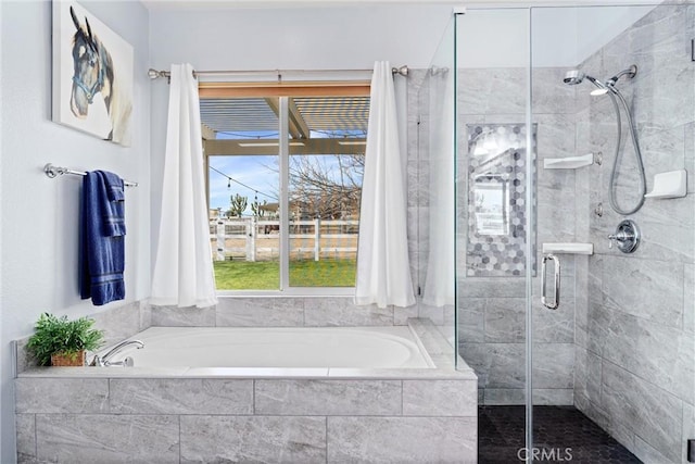 full bathroom featuring a shower stall and a garden tub