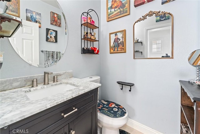 half bathroom featuring toilet, vanity, and baseboards