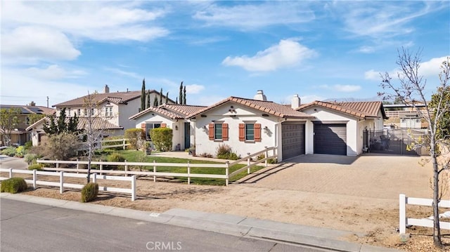 view of front of house with decorative driveway, fence, an attached garage, a chimney, and a tiled roof