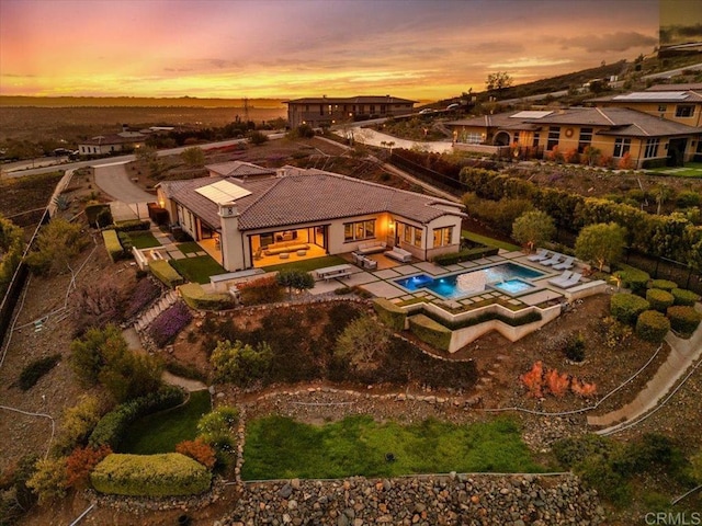 exterior space featuring a patio area, an outdoor pool, and an in ground hot tub