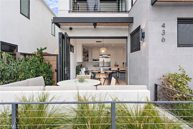 doorway to property featuring stucco siding and a balcony