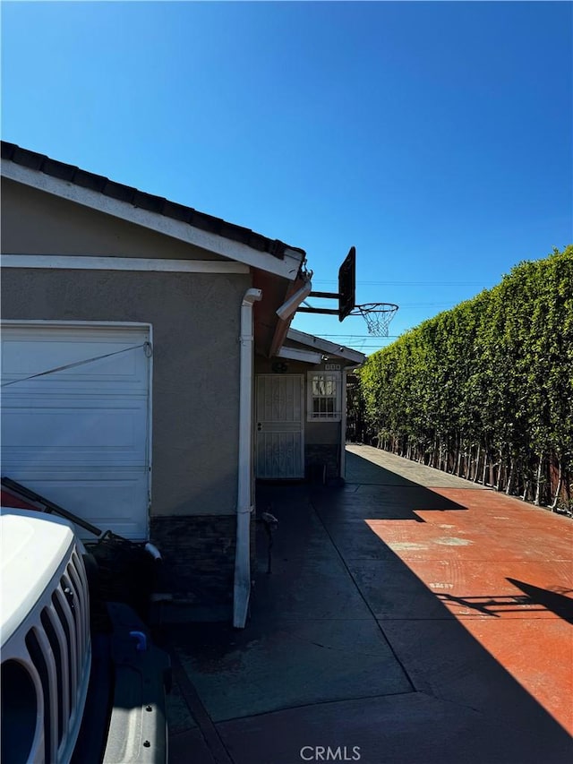 view of property exterior with a garage and stucco siding