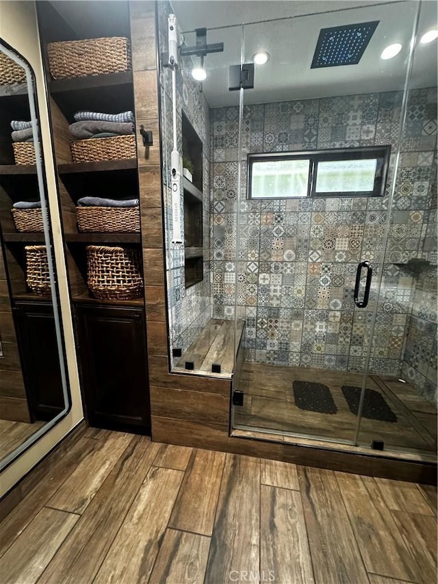 interior space with a shower stall and wood finished floors