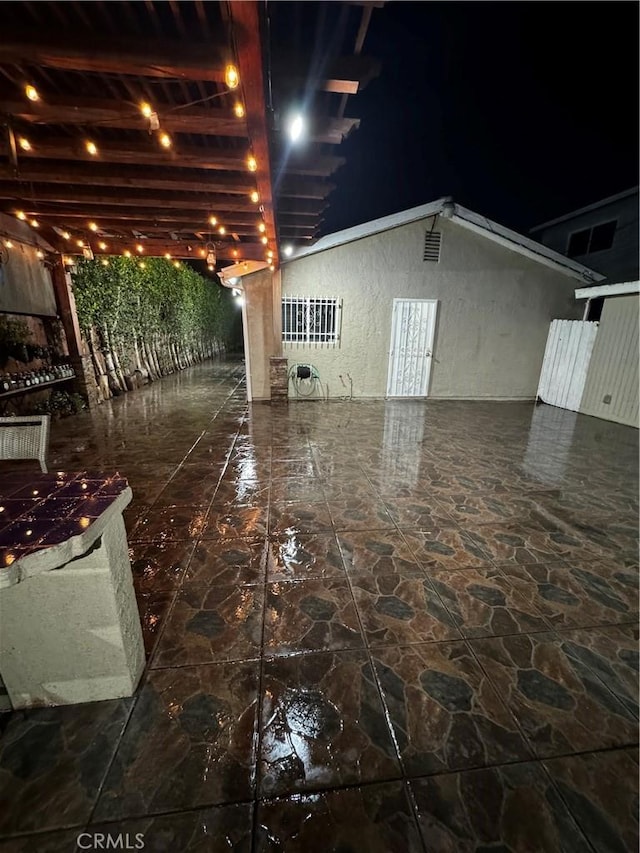 exterior space with stucco siding and a patio