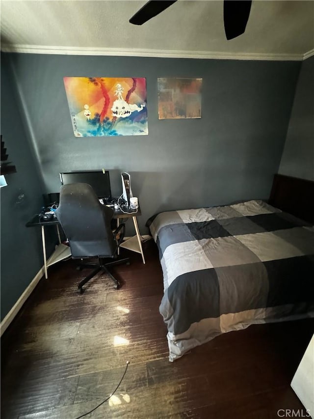 bedroom with crown molding, wood finished floors, and baseboards