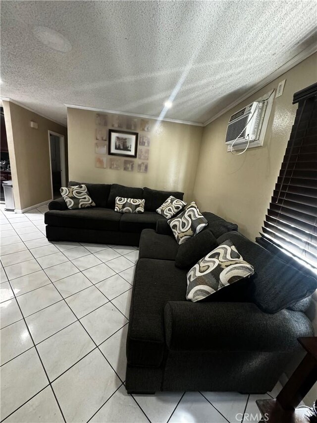 living room featuring light tile patterned floors, a textured ceiling, and a wall mounted AC