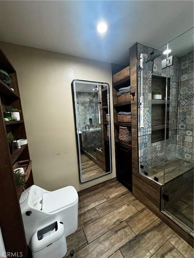 full bathroom with a shower stall, toilet, and wood tiled floor