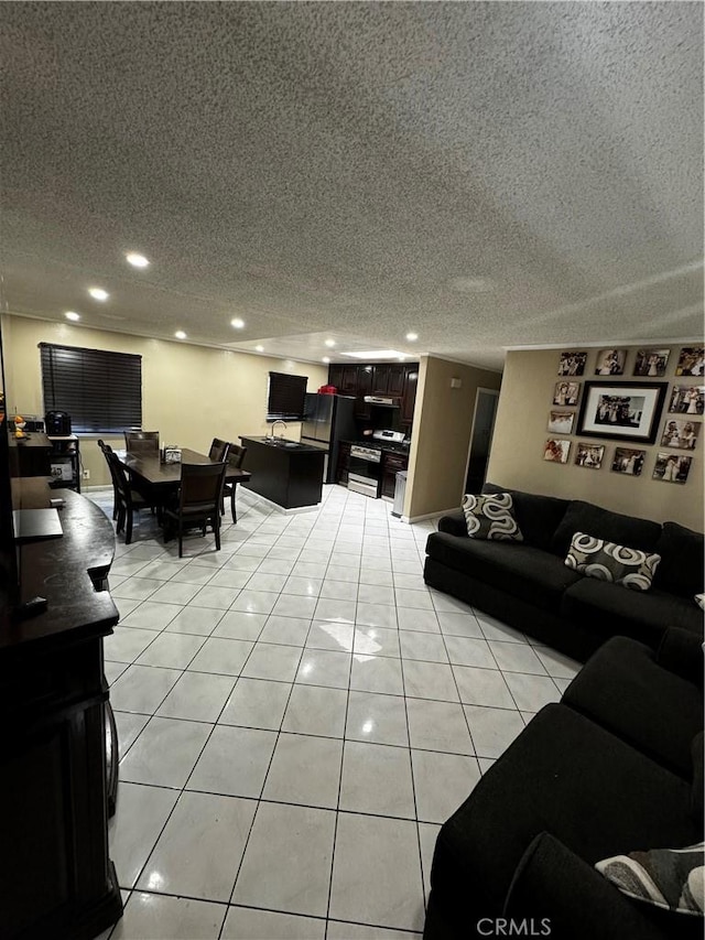 living room with light tile patterned flooring, recessed lighting, and a textured ceiling