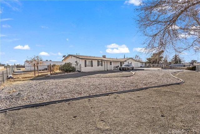 rear view of property with stucco siding and fence