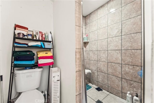 bathroom with tiled shower and toilet