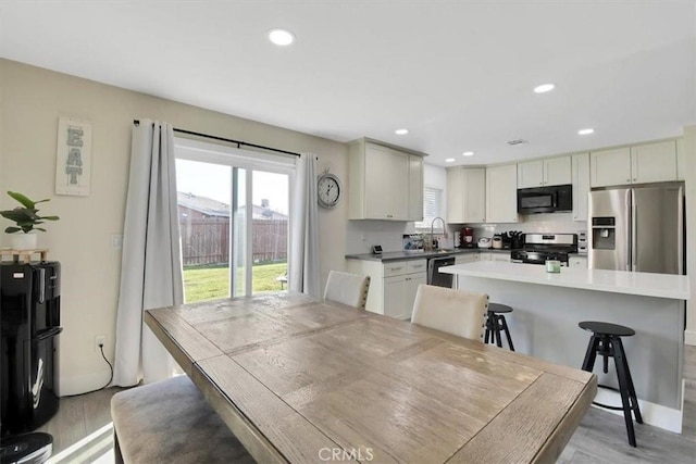 dining space featuring recessed lighting and light wood-style floors