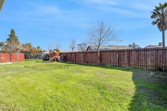 view of yard with a playground and a fenced backyard