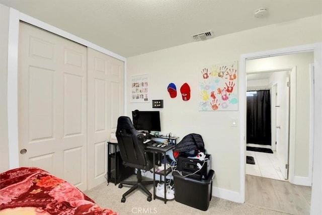 office space with visible vents, baseboards, and light wood-style floors