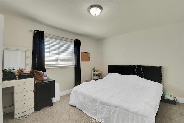 bedroom featuring baseboards and light colored carpet