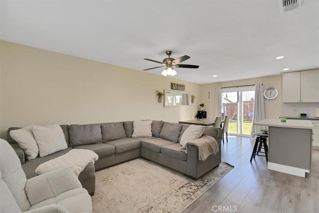 living area featuring recessed lighting, visible vents, light wood-style floors, and ceiling fan