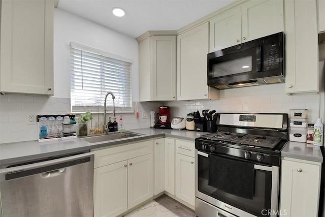 kitchen featuring a sink, light countertops, appliances with stainless steel finishes, marble finish floor, and backsplash