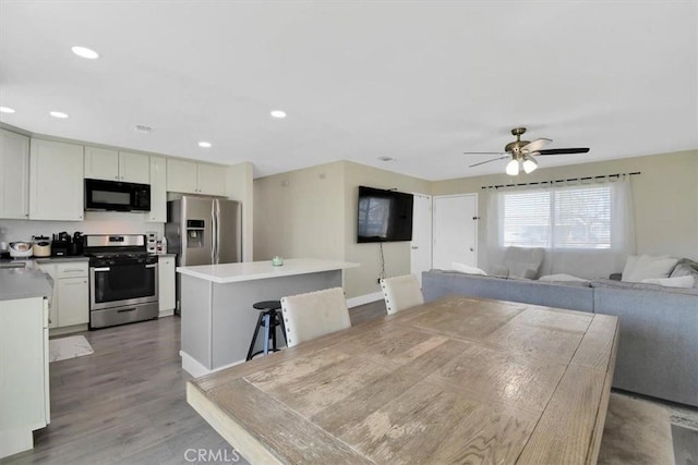 dining room featuring recessed lighting, baseboards, wood finished floors, and a ceiling fan