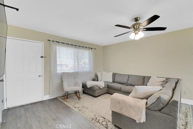 living area with ceiling fan, baseboards, and wood finished floors