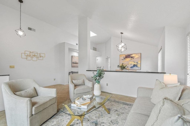 living area featuring light tile patterned floors, baseboards, visible vents, and high vaulted ceiling