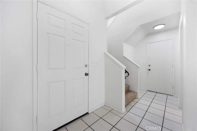 foyer entrance featuring light tile patterned floors and stairway