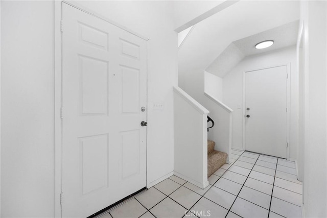 foyer with light tile patterned flooring and stairs