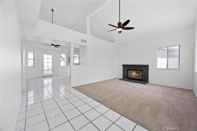 2100 Butterfield Ave, Bakersfield, CA 93304 - unfurnished living room featuring ceiling fan, light tile patterned floors, a fireplace, high vaulted ceiling, and light carpet