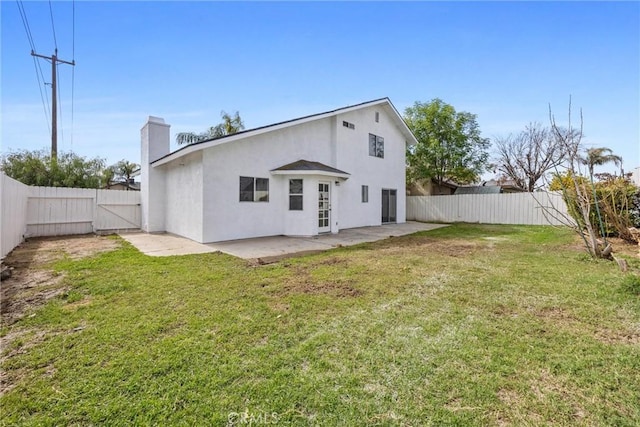 back of property featuring stucco siding, a patio, a lawn, and a fenced backyard