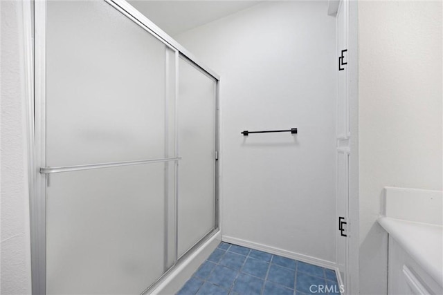 full bath with tile patterned flooring, a stall shower, and baseboards