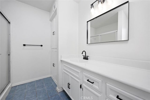 bathroom featuring a shower with door, tile patterned flooring, visible vents, baseboards, and vanity